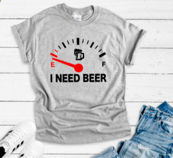 Gray t-shirt with 'I Need Beer' graphic on a wooden surface with jeans and sneakers.